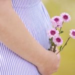 Femme enceinte qui porte des fleurs
