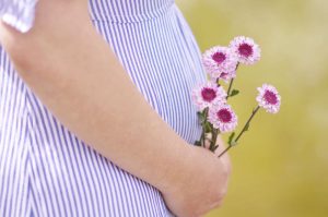 Femme enceinte qui porte des fleurs