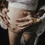 Couple qui pose ses mains sur ventre enceinte