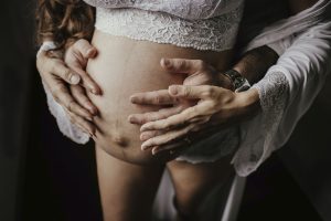 Couple qui pose ses mains sur ventre enceinte