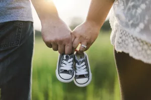 Parents qui portent chaussure de leur enfant