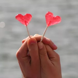Sucettes en forme de coeur tenues par un couple